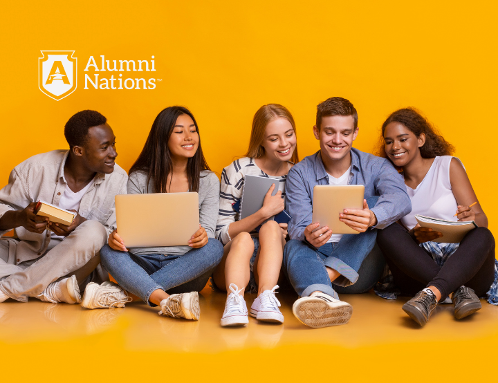 Diverse group of young alumni smiling while using digital devices on a yellow background.